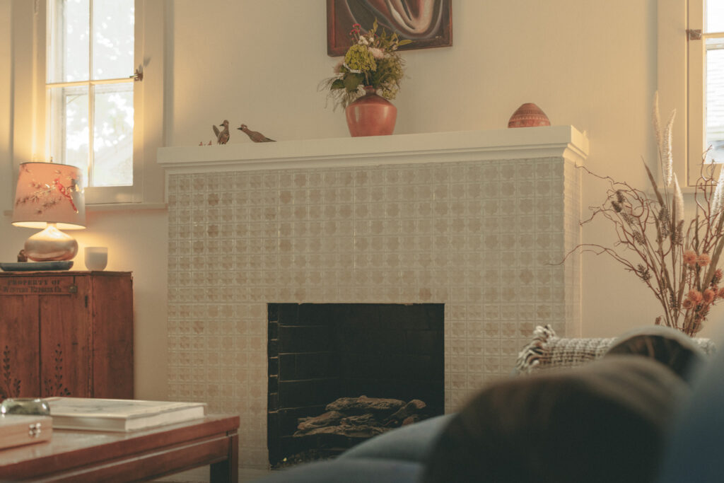 Tiled fireplace mantel with ceramic birds and terracotta planter in Denver craftsman home renovation
